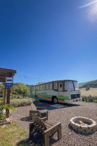 a bus parked on a gravel road with a bench at Refúgio Da Lua - Buss motorhome in Ametista do Sul