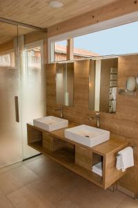 La salle de bains est pourvue de 2 lavabos et de 2 miroirs. dans l'établissement Der Heindlhof, à Neualbenreuth