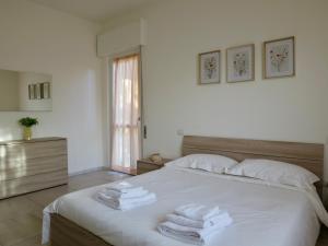 a bedroom with a white bed with towels on it at Lily House in Luino +23 photos