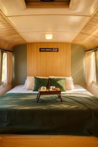 a bedroom with a bed with a table on it at Refúgio Da Lua - Buss motorhome in Ametista do Sul