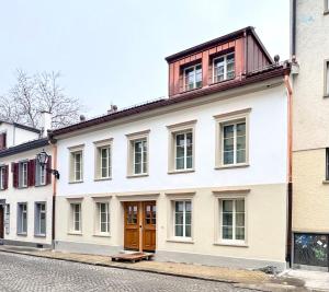 a white building with a wooden roof on a street at normalkonsum - premium apartments in St. Gallen