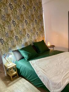 un letto con cuscini verdi in una stanza con un muro di La Longère a Vierzon