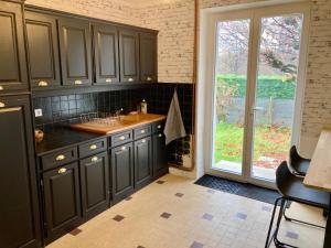 una cucina con un lavello e una grande finestra di La Longère a Vierzon