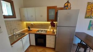 a kitchen with a refrigerator and a sink at La Dimora del Filosofo - Eraclito's Home in Olbia