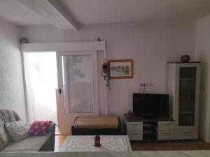 a living room with a couch and a television at Apartman Luka in Kupres