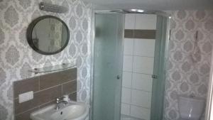 a bathroom with a sink and a mirror and a shower at Ferienwohnung Nähe Altstadt in Sassnitz +22 photos