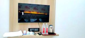 Ein Zimmer mit einem Fernseher an der Wand und Flaschen mit Cola. in der Unterkunft Hotel Premimum Kashi Satya Luxury-Parking Facility #Near KASHI VISHWANATH TEMPLE# in Varanasi + 17 Fotos