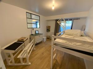 Un dormitorio con dos literas y un escritorio. en Appartement avec son jardin face au port d'Audierne, en Plouhinec