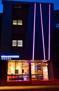 a building with purple and pink lights on it at Hotel Christina Plus in Bucharest