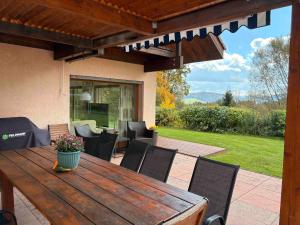 a wooden table and chairs on a patio at Dům nad Pržnem in Jablŭnka