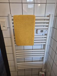 DiémozにあるBien proche de Aeroport St Exupéry Village de Marques et Lyonのバスルームの壁に黄色いタオルが掛けてある