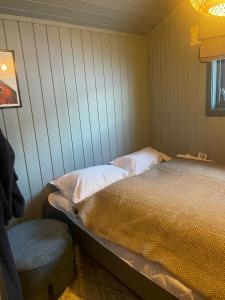 a bedroom with a bed and a chair at Sørstraumen View in Nordstraumen