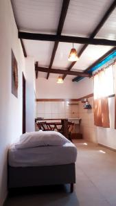 ein Schlafzimmer mit einem Bett und einem Tisch darin in der Unterkunft Apartamentos Nova Caraiva in Caraíva