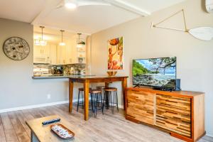een woonkamer met een keuken en een tafel met een televisie bij Kihei Akahi C210 in Wailea