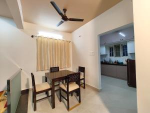 a dining room with a table and chairs and a kitchen at Homestay 2BHK, 3BHK, 4BHK, 5BHK call 8O8823-7972 in Narasimharaja Puram