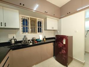 a kitchen with white cabinets and a brown refrigerator at Homestay 2BHK, 3BHK, 4BHK, 5BHK call 8O8823-7972 in Narasimharaja Puram +10 photos
