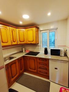 een keuken met houten kasten en een magnetron bij COPOS ALTO Elite in Monachil +6 foto's