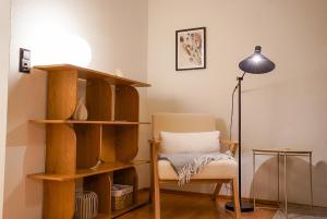 uma sala de estar com uma cadeira e um candeeiro em Brunnalm Blick Apartment em Veitsch