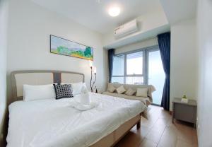 130 Sqm Luxurious Modern 3 Bedrooms Facing Manila Bay Sunset, Airports, Okada, Solaire, MOA with Free Parking في مانيلا: غرفة نوم بها سرير أبيض كبير وأريكة +51 صورة