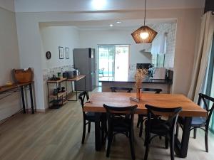 eine Küche und ein Esszimmer mit einem Holztisch und Stühlen in der Unterkunft Casa de Campo com piscina Ninho Verde 2 in Pardinho