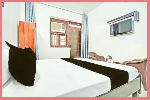 een hotelkamer met een bed en een tv bij Hotel Ganga Roop Residency in Kankhal