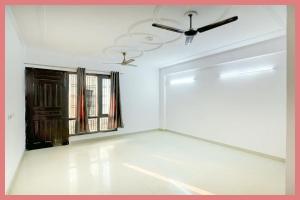 een lege kamer met een plafondventilator en een raam bij Hotel Ganga Roop Residency in Kankhal