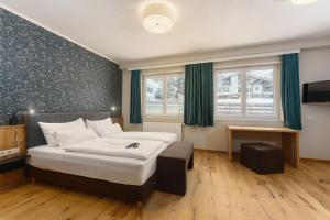 a bedroom with a large bed and a television at Landhaus Hubertus Wellness & Breakfast in Schladming
