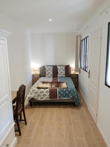a bedroom with a bed and a wooden floor at Appartement neuf & climatisé - 3 mins centre-ville in Prades