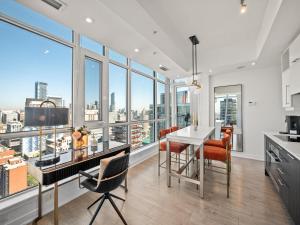 a kitchen with a table and chairs and large windows at Sovitel Suites - Toronto's Entertainment District in Toronto