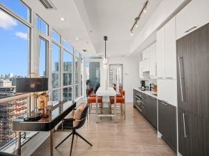 a kitchen with a table and some chairs and windows at Sovitel Suites - Toronto's Entertainment District in Toronto
