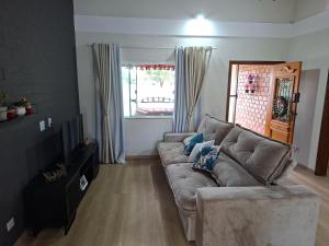 ein Wohnzimmer mit Sofa und Fernseher in der Unterkunft Casa de Campo com piscina Ninho Verde 2 in Pardinho