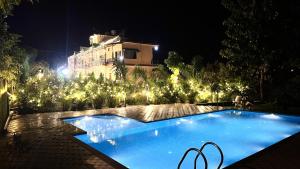 ein Schwimmbad vor einem Gebäude bei Nacht in der Unterkunft Corbett Nature Walk - Forest View Swimming Pool in Rāmnagar + 43 Fotos