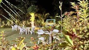 eine Gruppe weißer Stühle und Tische auf einem Feld in der Unterkunft Corbett Nature Walk - Forest View Swimming Pool in Rāmnagar