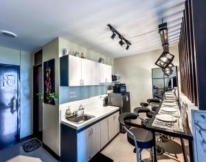 a kitchen with a sink and a table with chairs at Meraki Space Mactan Cebu in Lo-oc