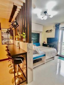 a bedroom with a bed and a table and a desk at Meraki Space Mactan Cebu in Lo-oc +6 photos