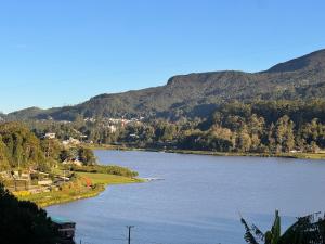 Una vista de un río con montañas al fondo. en Succulent Homestay, en Nuwara Eliya