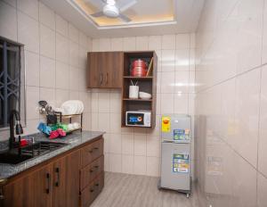 a kitchen with a refrigerator and a sink at De Awon's Luxury Hotel in Kasoa