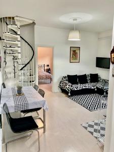 Una sala de estar con una mesa y una escalera de caracol. en Appartamento Lella con meravigliosa vista vicino alle Terme zona Bagni, en Acqui Terme