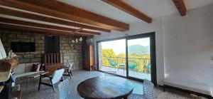 Maison de Charme Vue Exceptionnelle Mer & Montagne في كامبومورو: غرفة معيشة مع طاولة ونافذة كبيرة