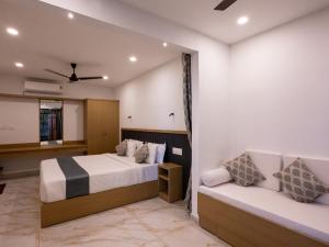 un dormitorio con dos camas y un sofá en Puthooram Seaview Cliff Resort, en Varkala