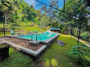 uma piscina com uma fonte em um quintal em Sandungira Eco Resort em Belihul Oya