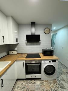 een keuken met een fornuis en een magnetron bij Apartamento El Alfar in Alhama de Aragón +5 foto's