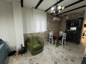 een woonkamer met een groene stoel en een tafel bij Apartamento El Alfar in Alhama de Aragón