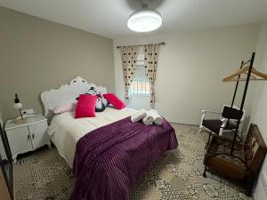een slaapkamer met een groot bed met roze kussens bij Apartamento El Alfar in Alhama de Aragón