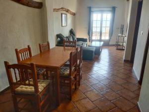 un salon avec une table et des chaises en bois dans l'établissement Casa Mirador, à Cáñar