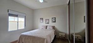 ein weißes Schlafzimmer mit einem Bett und einem Fenster in der Unterkunft Casa de Campo com piscina Ninho Verde 2 in Pardinho + 42 Fotos