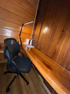 a desk with a chair and a lamp on it at Cabaña Río San Carlos Ecolodge in Boca Tapada