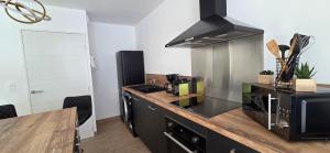 a kitchen with a sink and a stove top oven at Joli T2 cozy, proche plages, Terra Doru B02 in Propriano