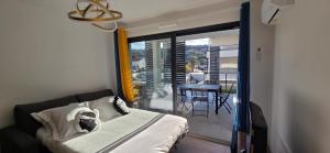 a bedroom with a bed and a view of a balcony at Joli T2 cozy, proche plages, Terra Doru B02 in Propriano