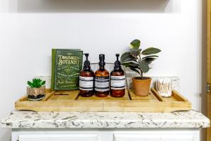 uma bandeja de madeira com quatro garrafas de vinho em um balcão em Jungle House Luxury Homes - Columbus Downtown Short North - Walk to Convention Center & Nationwide Arena - Sleeps up to 10 - Free Parking - Over 5,800 Five Stars em Columbus mais 42 fotografias